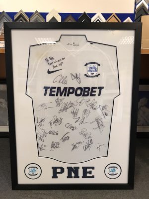 Preston North End Signed Shirt with badges and text cut out.